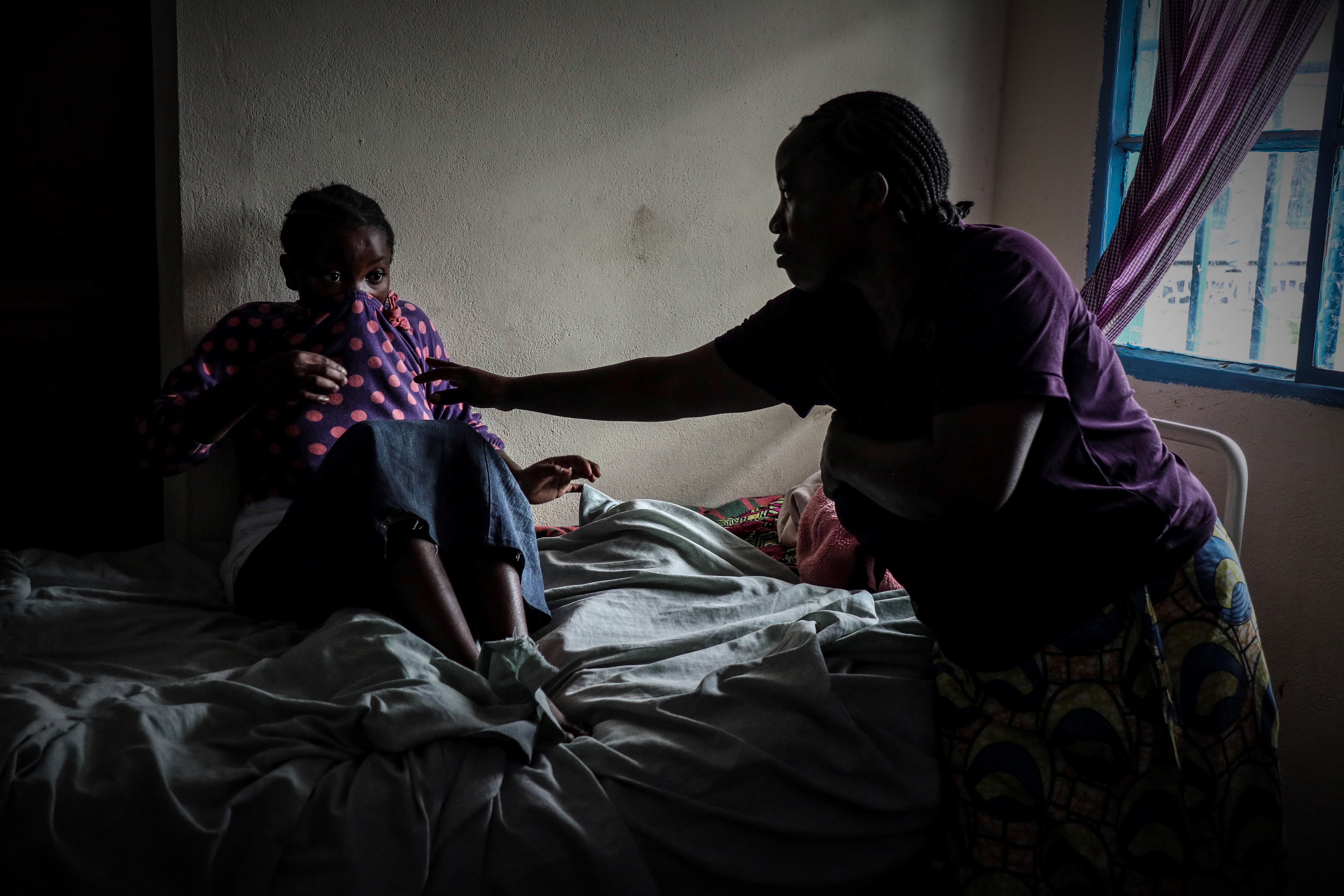 Une mère aux cheveux de sa fille souffrant des troubles mentaux au centre Tulizo Letu