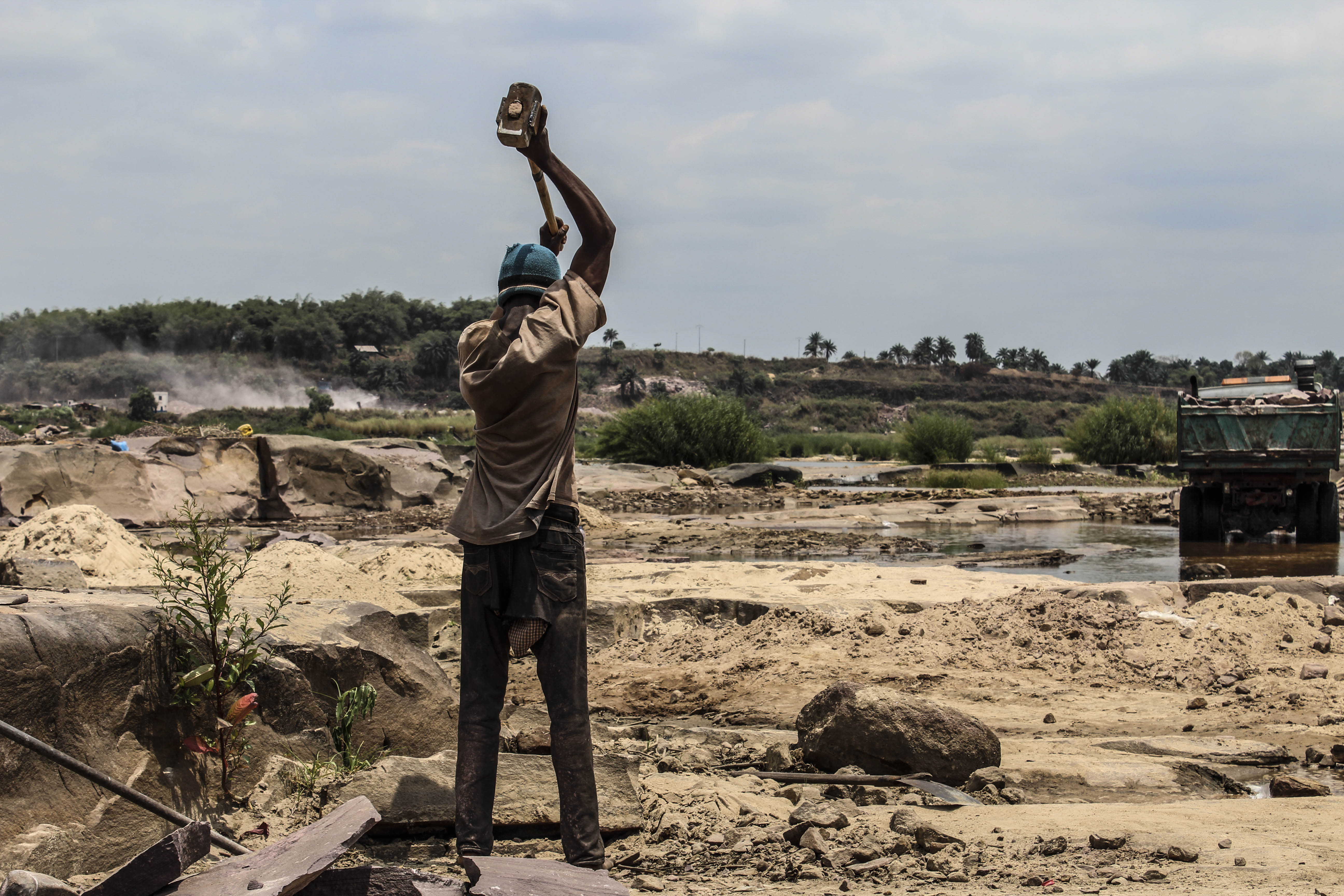 Dans la carrière, en saison sèche, l’exploitation est favorable. De loin, une benne remplie de moellons à Mont Ngafula