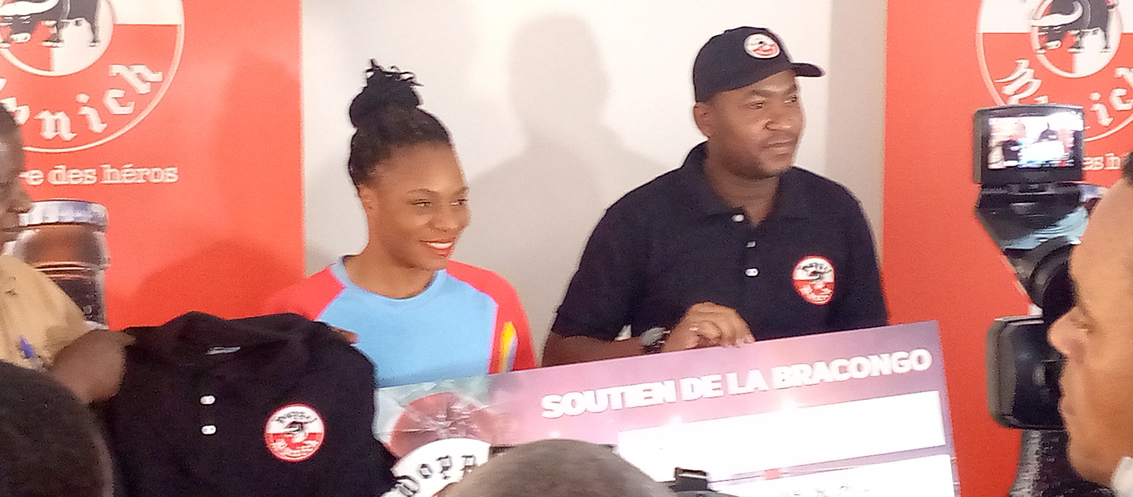 Marcela Sakobi entrain de recevoir son chèque des mains de Jules Bolenge