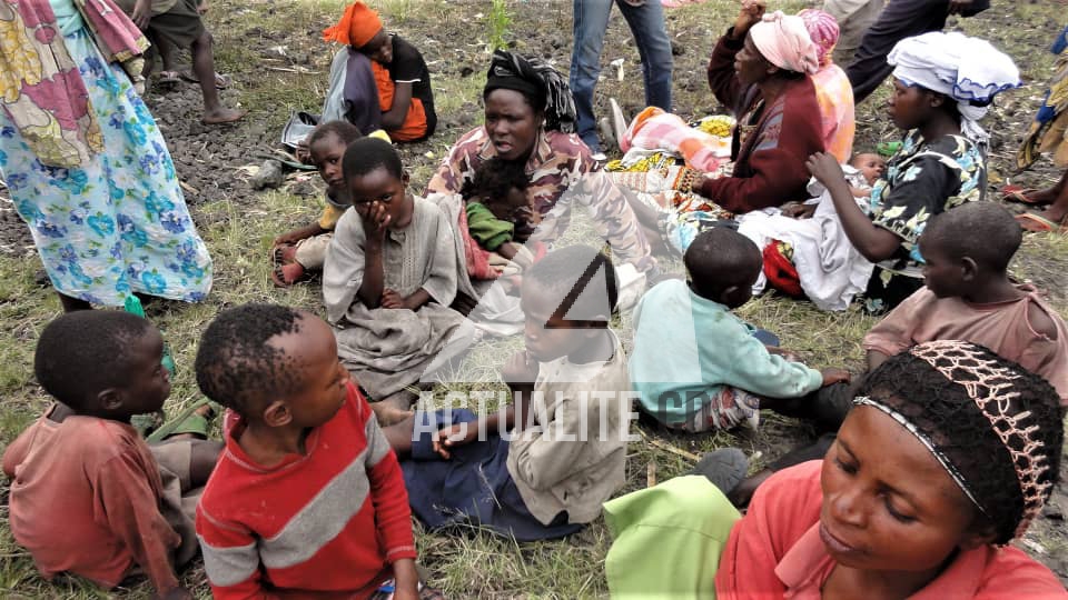 1.	Femmes et enfants assis dans une cour à Kanyaruchinya après avoir fuient les combats entre Fardc et un groupe armé