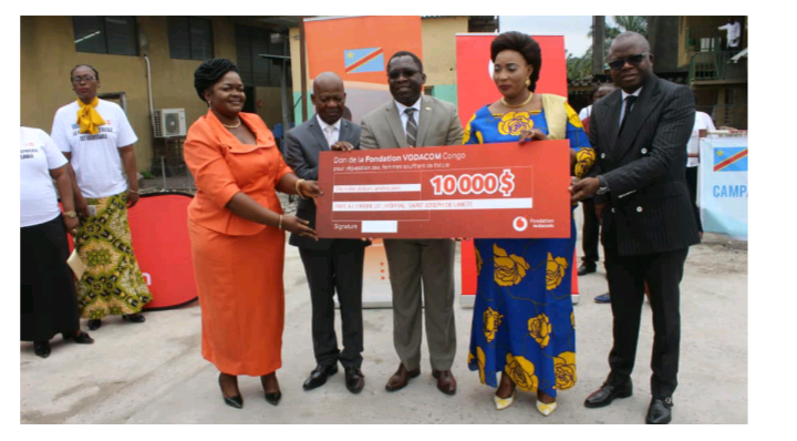 Remise du chèque factice de 10 000 USD à la Ministre du Genre, Familles et Enfants par le DGA de Vodacom Congo