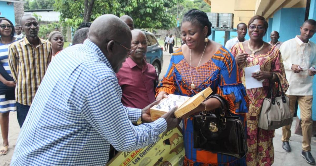 Collete Tshomba en train de remettre des fournitures scolaires et matériels didactiques au préfet du collège Saint Michel