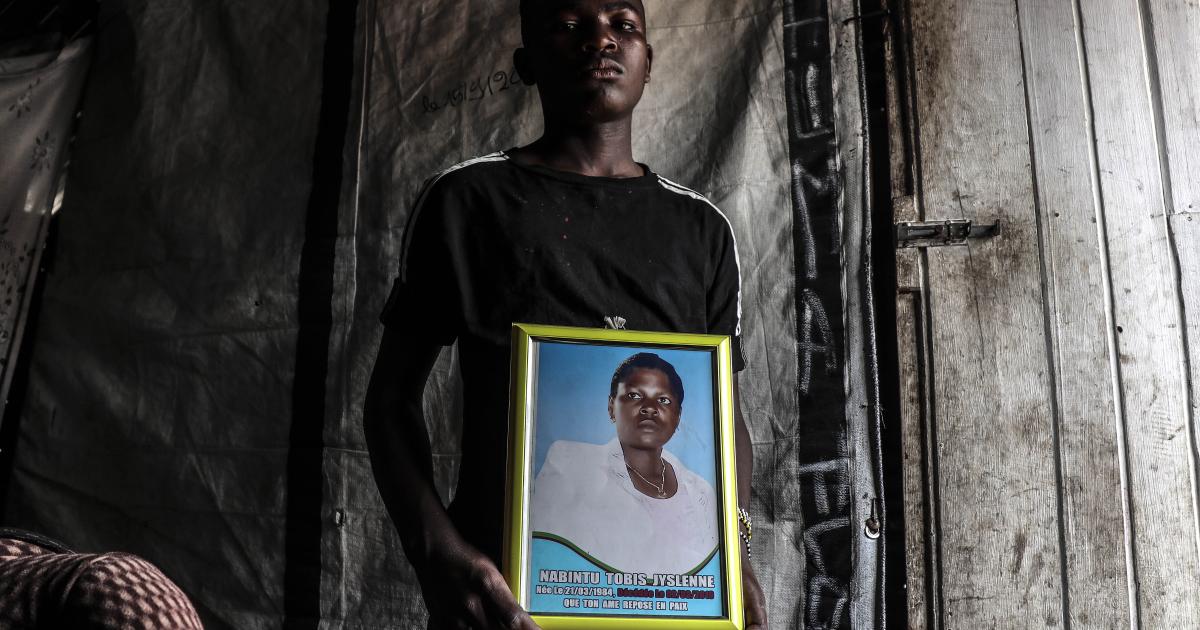 Un jeune adolescent, porte le portrait de sa mère, Nabintu Tobis, tuée devant une pharmacie
