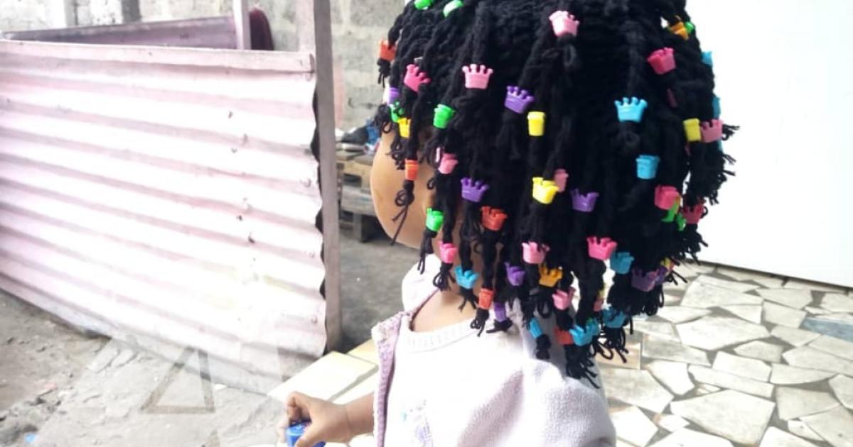 Petite fille portant une perruque confectionnée par Lucie Lusamba