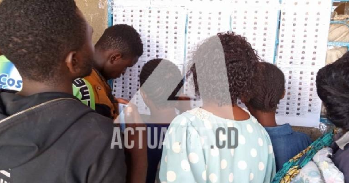 Les électeurs cherchent leurs noms sur les listes affichées au bureau de vote à Kolwezi.