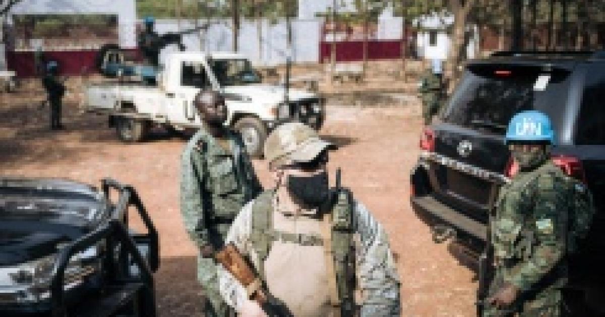 AFP/Un Casque bleu rwandais de la Minusca (d), un garde russe d'un groupe de sécurité privée (c) et un membre de la garde présidentielle centrafricaine (g) assurent la protection du président Faustin Archange Touadéra, le 27 décembre 2020 à Bangui