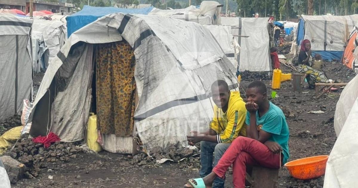 Des jeunes déplacés devant leur cabane sur le site de Kanyaruchinya