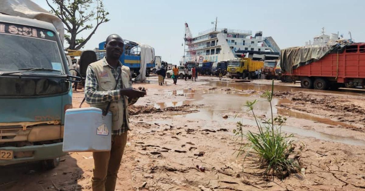 John, mobilisateur communautaire au port de la SNCC de Kalemie dans le Tanganyika, parcourt les alentours du port avec sa glacière de vaccins, à la recherche des familles voyageant avec des enfants pour les vacciner