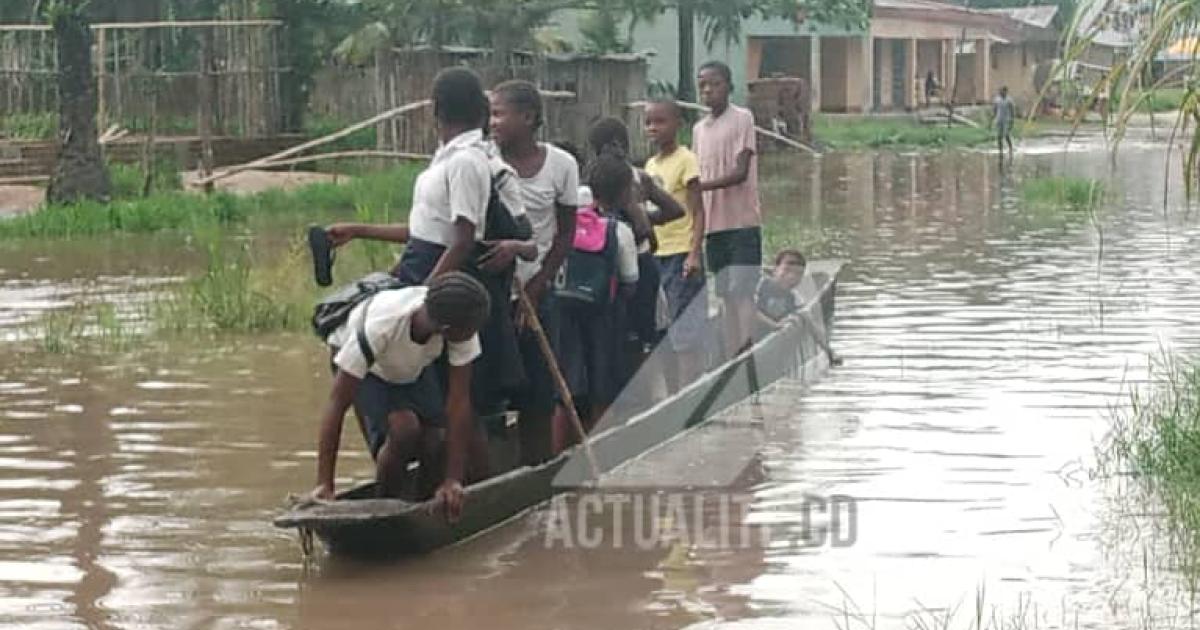 Des écoliers dans une pirogue de fortune pour faire face aux inondations à Isangi