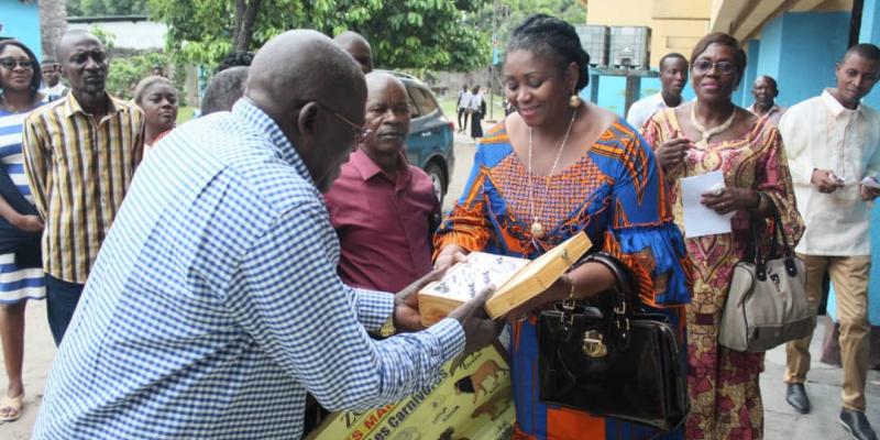 Collete Tshomba en train de remettre des fournitures scolaires et matériels didactiques au préfet du collège Saint Michel