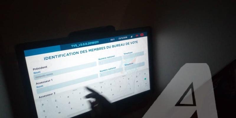 Un électeur manipule la machine à voter dans un bureau de vote.