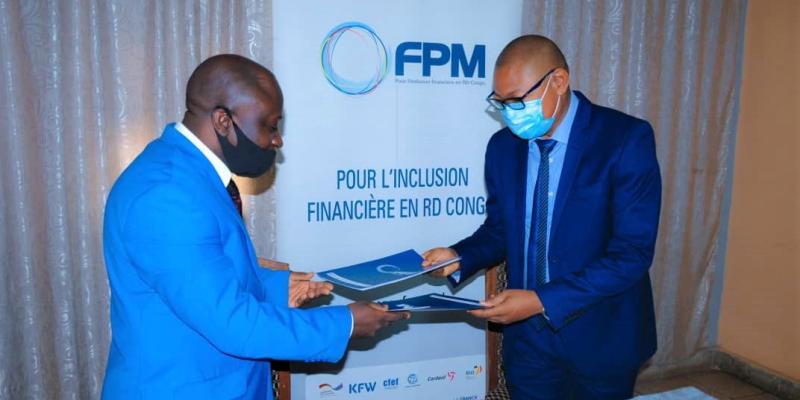 Le  Gérant de la CAMEC, M. Masha MATONDO, à gauche, et Mr Carlos KALAMBAY KABANGU, DG du FPM SA, à droite, lors de la signature du contrat de financement.