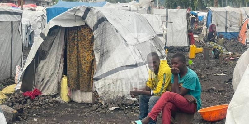 Des jeunes déplacés devant leur cabane sur le site de Kanyaruchinya