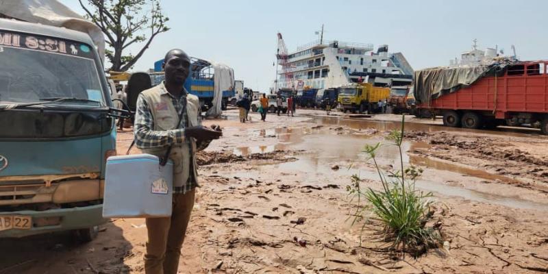 John, mobilisateur communautaire au port de la SNCC de Kalemie dans le Tanganyika, parcourt les alentours du port avec sa glacière de vaccins, à la recherche des familles voyageant avec des enfants pour les vacciner