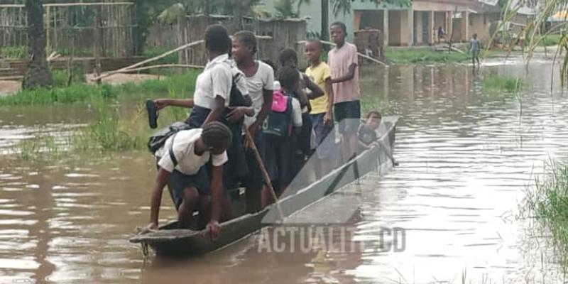 Des écoliers dans une pirogue de fortune pour faire face aux inondations à Isangi