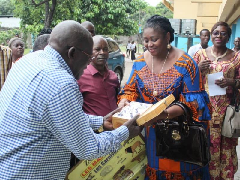 Collete Tshomba en train de remettre des fournitures scolaires et matériels didactiques au préfet du collège Saint Michel