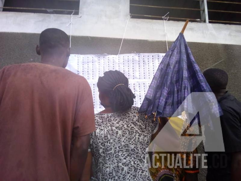 Les electeurs devant des listes affichées dans un centre de vote à Ndjili/Kinshasa. Photo Auguy Mudiayi