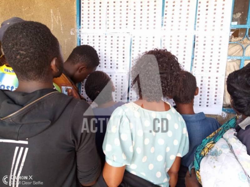 Les électeurs en train de consulter les listes électorales devant un bureau de vote.