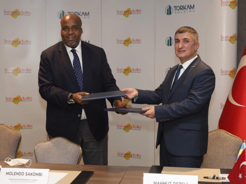 A gauche, Aimé Molendo Sakombi, ministre des Affaires foncières lors de la signature du protocole avec TORKAM Holding 