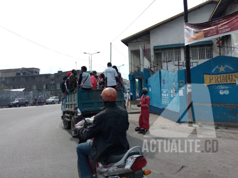 Les gens recourant à des camions de marque Ben et des tricycles comme moyen de transport