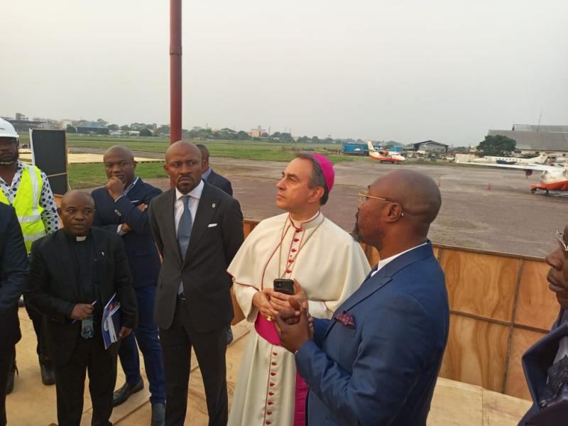 Patrick Muyaya et Mgr Ettore Balestrero (Nonce apostolique) à l’aéroport de Ndolo
