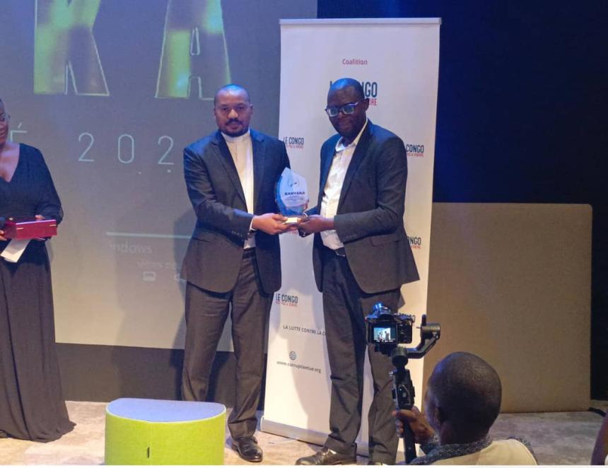 Jean-Baptiste Kasekwa recevant le prix Kanyaka, des mains d'Eric Nsenga, porte parole de l'ECC