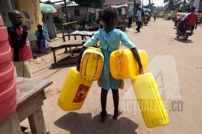 Dorcas, fillette de 7ans qui va puiser de l'eau avec ses bidons de 25 litres Dorcas, fillette de 7ans qui va puiser de l'eau avec ses bidons de 25 litres