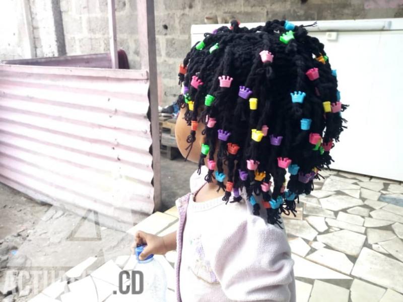 Petite fille portant une perruque confectionnée par Lucie Lusamba Petite fille portant une perruque confectionnée par Lucie Lusamba