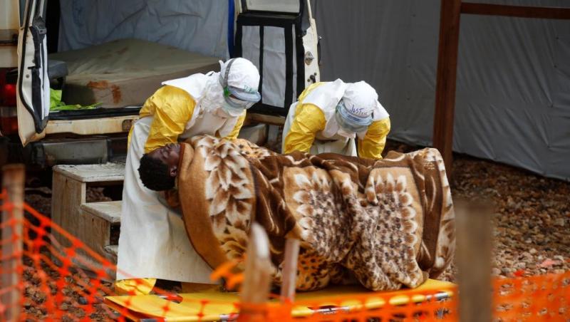 Des employés du centre Ebola de Butembo prennent en charge une femme atteinte d'Ebola, le 28 mars 2019 Des employés du centre Ebola de Butembo prennent en charge une femme atteinte d'Ebola, le 28 mars 2019
