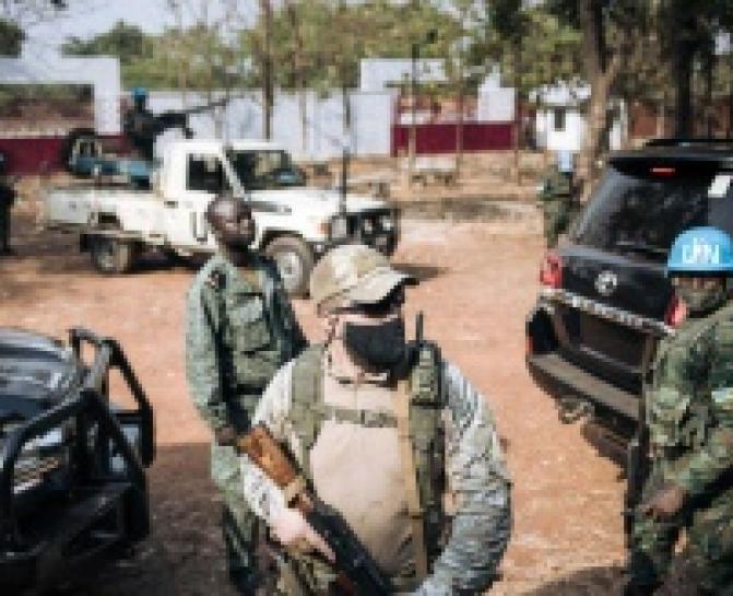 AFP/Un Casque bleu rwandais de la Minusca (d), un garde russe d'un groupe de sécurité privée (c) et un membre de la garde présidentielle centrafricaine (g) assurent la protection du président Faustin Archange Touadéra, le 27 décembre 2020 à Bangui