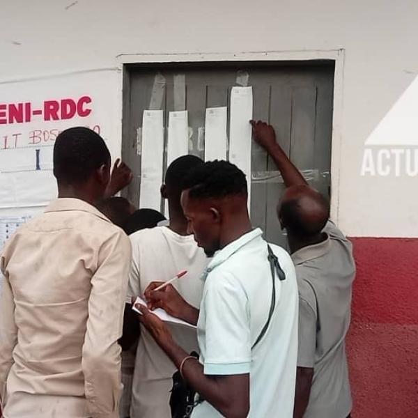 Les électeurs consultent les résultats devant un bureau de vote à Bandundu